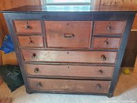 Front view of the antique two tone wooden buffet showing drawer arrangement and overall condition.
