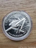 Obverse of silver coin showing WWII fighter plane and inscriptions about Battle of Britain.