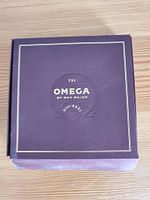 Closed purple Omega box with gold embossed text reading 'TXI Omega by Max Major'