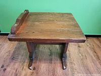 Top view showing the natural wood grain, scalloped back edge, and visible cracks on the tabletop.