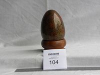 Front view of cloisonne egg on wooden stand with ruler showing approx 7 cm height.