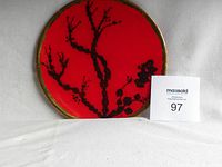 Front view of the red cloisonné plate showing black blossoming tree branch design and gold-tone rim on a white background with lot number card.