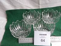 Four matching crystal bowls positioned with scales to indicate size and shape detail.