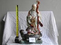 Front view of statue with measuring tape showing approximately 17 inches tall
