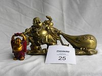 Photo showing both Lucky Buddha figurines together with scale and lot number card