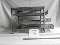 Front view of a three drawer metal desk organizer showing the top perforated shelf and three mesh drawers stacked vertically.