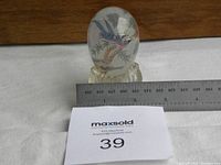 Glass egg with ruler for scale, showing size approximately 2.5 inches tall.