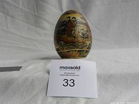 Full view of the front of the decorative Satsuma egg showing intricate hand-painted scene with Japanese women on a boat and floral borders.