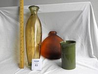 Three vases displayed side by side with a measuring ruler for scale, showing the size and shape of each vase.
