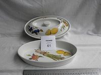 Two oval ceramic vegetable serving dishes, one with lid showing fruit and vegetable decoration and a ruler for scale
