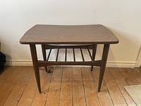 Front view of the rectangular mid century modern wooden side table showing smooth top and slatted shelf below.