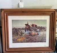 Framed cowboy art print "Camp Cook's Trouble" by Charles M. Russell, showing the horse and campfire scene in full.