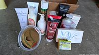 Photo showing various body and hair care products including lotions, shampoos, boxed soaps and a handheld mirror arranged on a surface.