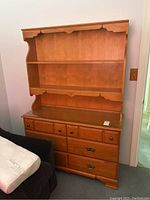 Front view of the wooden buffet and hutch showing drawers and open shelving.