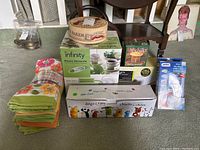 Photo showing Brie Baker box, Infinity Thermo Pot box, kitchen towels, and other packaged kitchen items