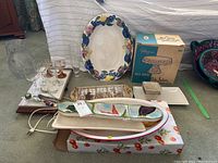 Wide view of lot showing large floral platter, boxed cake salver, electric heated tray, clear jug and glasses, and various serving dishes.