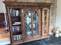Full front view of assembled bookcase showing carved wood and stained glass doors