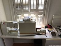 Overview of Bernina sewing machine on table with carrying case, rulers and accessory bins