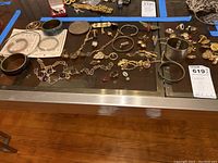 Assortment of costume jewelry laid out including bangles, bracelets, necklaces, and pins