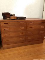 Front view of teak veneer dresser with eight drawers