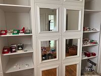 Wide view of closet shelves showing multiple boxed bells and other items to contextualize the lot size and storage.