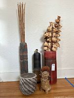 Full view showing five decorative vases and sculpture arranged on floor; includes dried flowers and sticks in vases