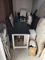 Storage unit view showing desk, storage chest, mattress, bed rails, boxes