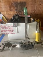 Come along pulley with green handle and ball joint pickle fork placed in front of a box labeled with lot contents.