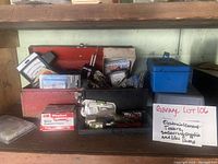 Photo of two metal tool boxes on a shelf filled with various electrical current testers, wire connectors, plugs, and electrical accessories.