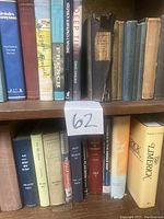 Photo of two middle shelves of a bookcase containing hardcover books including 'Abeokuta's Anonymous', 'French', 'Deep Time' and historical volumes.
