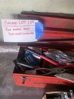 Photo of the red metal toolbox filled with assorted tools including pliers, hammer, and socket sets