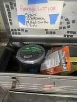 Opened Craftsman metal toolbox showing duct tape, Charge-IT Restore battery maintainer, and other assorted tools