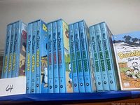 Wide view of five slipcased Disney sets and one standalone Donald Duck hardcover on blue display shelf