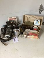 Entire air paint tool kit with sprayer, motor, hoses, booklet, and several accessory containers and boxes.