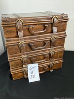 Photo of faux leather box with handle and buckle detailing, stacked style design.