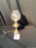 Full view of the brass lamp with frosted etched glass shade. Shows the cord, base, and overall height.