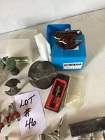 Close-up photo of Katana router bit head in blue box and assorted individual bits with packaging.