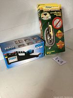 Box of Foot Gym exercise device and box of Richard Vacuum sand hose side by side on table.