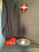 Front view of the kids adjustable punching ball standing on weighted base, red and black colors with star decals