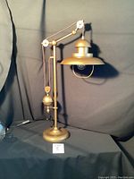Full view of the lamp showing the height and base on a dark cloth background.