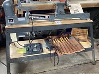 Full view of lathe on stand with chisels and accessories on lower shelf