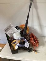 Paint sprayer with accessories on table including instruction manual, mask, hose, and extension cord