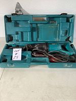 Makita reciprocating saw in open carrying case showing saw and storage compartments.