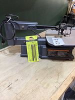 Full view of Ryobi scroll saw with power cord and specialty blade set placed in front of the base.