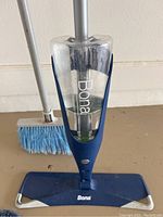 Front view of Bona mop with clear cleaning solution container filled with liquid and blue mop base.