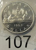 Reverse side of the 1963 Canadian silver dollar showing the voyageur canoe design and the year 1963.