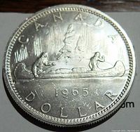 Reverse side of 1965 Canada silver dollar depicting canoe scene with 'CANADA DOLLAR 1965' inscription.