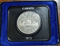 Close-up of the 1972 Canada silver dollar coin in a black holder with blue lining showing details of the coin design.