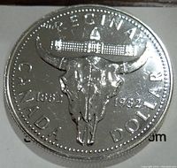Front side of the 1982 Canada silver dollar showing the bison skull with totem pole design and inscriptions.
