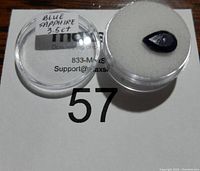 Photo of 3.5 carat blue sapphire gemstone in plastic container with label.